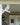 Decorative white cardinal bracket on a post with a house door in the background