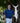 Man holding a large white swordfish wall art outdoors with trees in the background