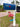 Blue mailbox with a pink flamingo bracket  on a white post.