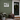 A white rectangle white pvc  'Happy Holidays' sign with snowflake cutouts is mounted on a sage green front porch wall next to a dark green door with a wreath.