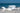 White mermaid holding wine glass wall art on a sandy beach with ocean in the background