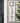 white pvc house plaque featuring a hummingbird in square cutout above the house numbers displayed vertically shown here on the front of a grey house
