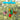 hand-painted butterfly mobile featuring 4 colorful butterflies and a red flower hanging from a blue crosspiece with a blurred green background

