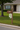 white pvc mailboxbracket in shape of hot air balloon with frame on brown mailbox post in front of tan house
