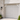 white pvc hummingbird decorative brackets mounted near the top corners of garage door with a brick wall of house