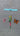 hand-painted butterfly mobile featuring 4 colorful butterflies and a red flower hanging from a blue crosspiece moving gently in the breeze

