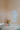 A large white seahorse wall decor cutout decor piece made from pvc mounted on a peach-colored bathroom wall above a white marble tub, with smaller white starfish pvc decorations on the left.