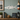 Decorative snook fish white pvc wall art on a wooden shelf with books, a lantern, and a sign.