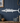 White wahoo fish-shaped wall decoration on a blue paneled wall with nautical decor.