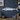 White wahoo fish-shaped wall decoration on a blue paneled wall with nautical decor.
