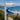 A white mailbox on a post with a large blue whale handpainted on a bracket under the mailbox